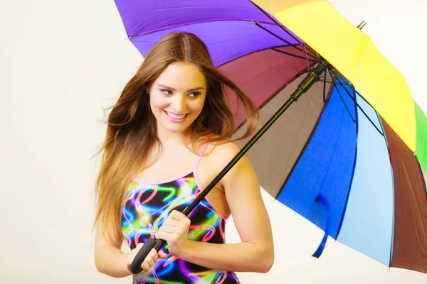 Glückliche Frau posiert in Badeanzug und buntem Regenschirm — Stockfoto