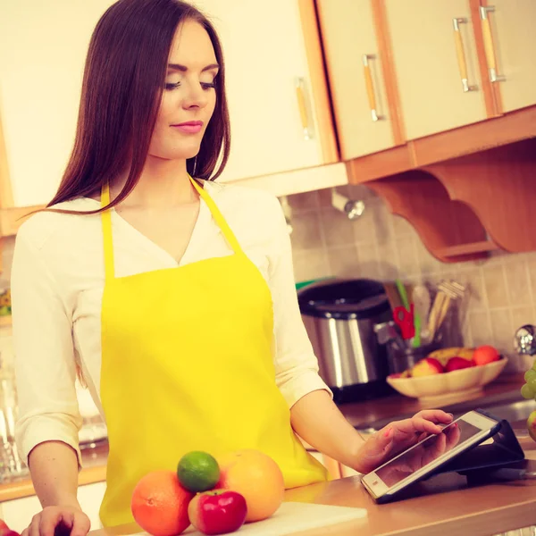 Γυναίκα νοικοκυρά στην κουζίνα χρησιμοποιώντας tablet — Φωτογραφία Αρχείου