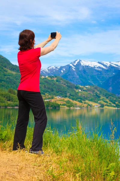 Turista tomando fotos en noruego fiordo — Foto de Stock