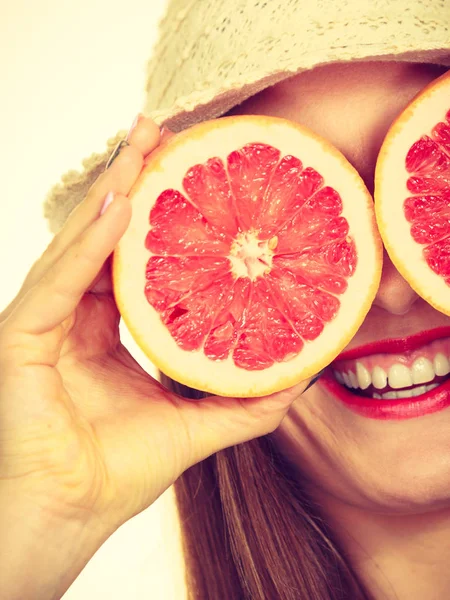 Žena drží v rukou dvě poloviny grapefruitového citrusového ovoce — Stock fotografie