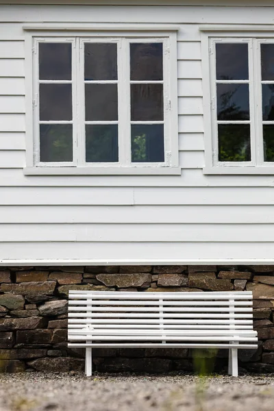 Symmetrische weiße Bank vor traditionellem Haus. — Stockfoto