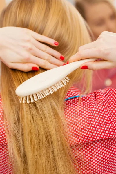 Mujer cepillándose el pelo largo en el baño — Foto de Stock