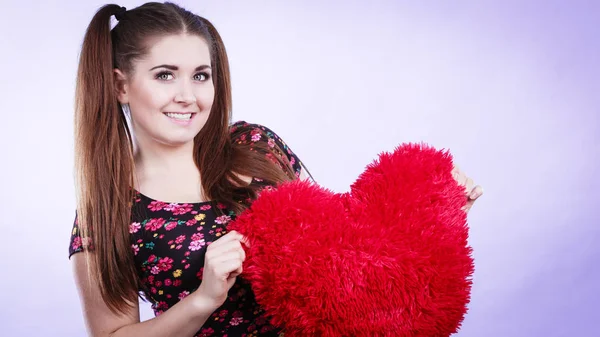 Mujer feliz sosteniendo almohada en forma de corazón —  Fotos de Stock