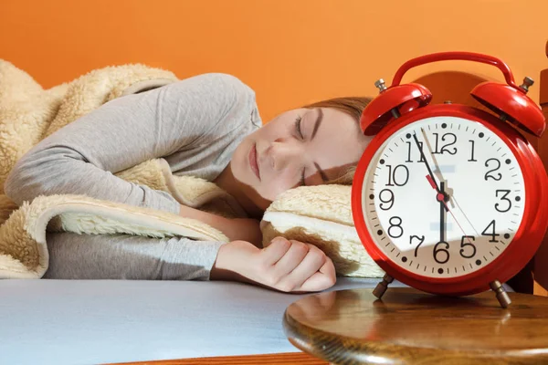 Mujer durmiendo en la cama con reloj despertador . —  Fotos de Stock