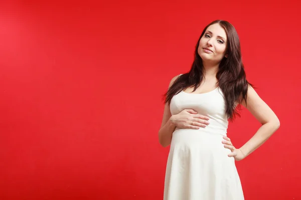 Femme enceinte debout en robe blanche — Photo