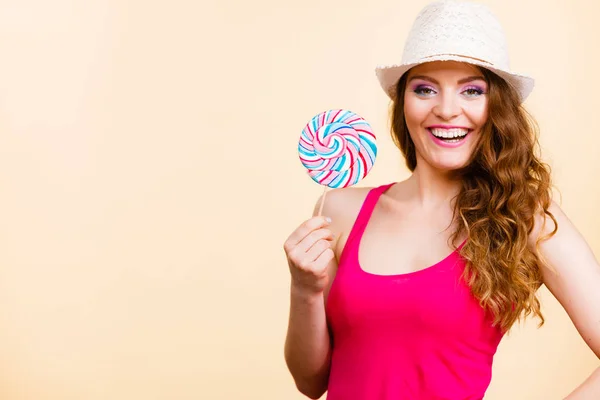 Mujer sostiene colorido caramelo piruleta en la mano —  Fotos de Stock