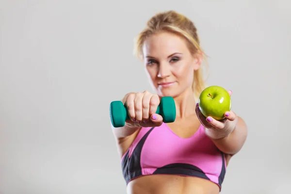 Диетическое тело. Девушка держит гантели и яблочные фрукты — стоковое фото