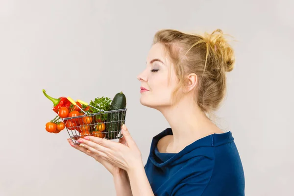 Femme tient panier avec des légumes, odeur — Photo