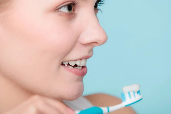 Mujer sostiene cepillo de dientes con pasta de dientes limpieza de dientes —  Fotos de Stock