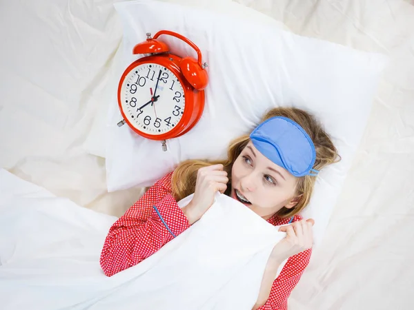 震惊的女人穿着睡衣抱着时钟睡过头了 — 图库照片