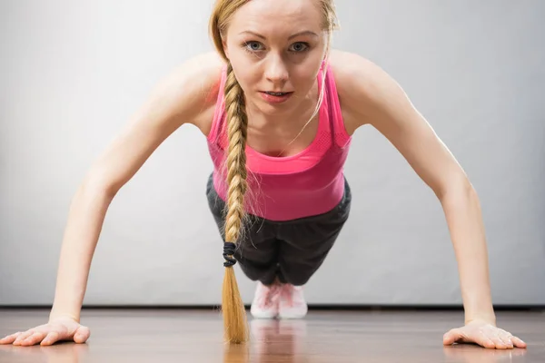 Jovem mulher vestindo sportswear fazendo flexões — Fotografia de Stock