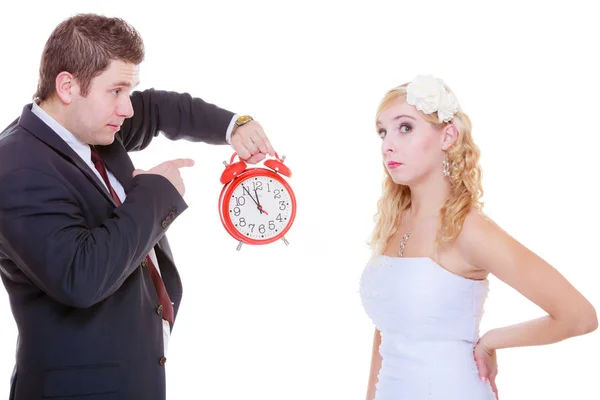 Groom holding big red clock yelling and bride Royalty Free Stock Photos
