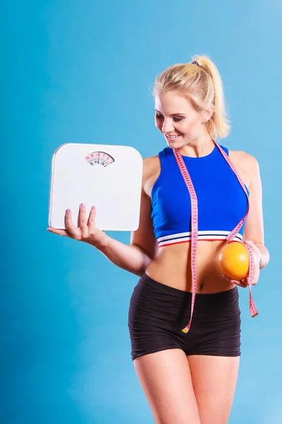 Ajuste mujer sostiene peso escala pomelo — Foto de Stock