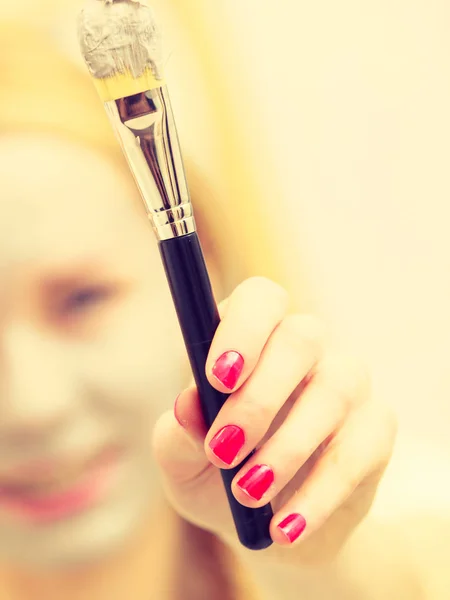 Femme appliquant avec un masque de boue d'argile brosse sur son visage — Photo