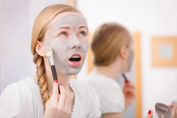 Woman with grey clay mud mask on her face — Stock Photo, Image