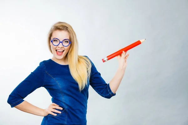 Lycklig kvinna som håller stora överdimensionerade penna — Stockfoto