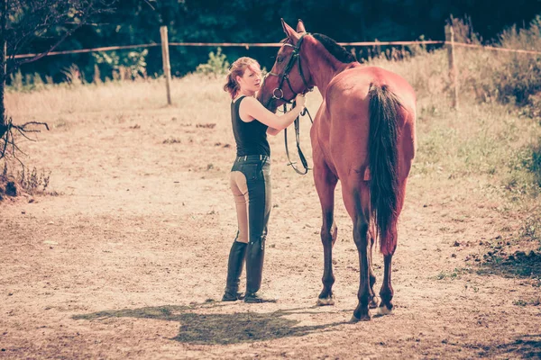 Mulher de hóquei andando com cavalo no prado — Fotografia de Stock