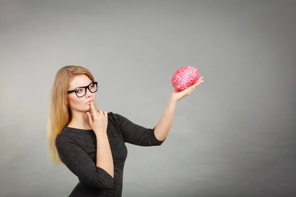 Женщина думает и держит фальшивый мозг — стоковое фото