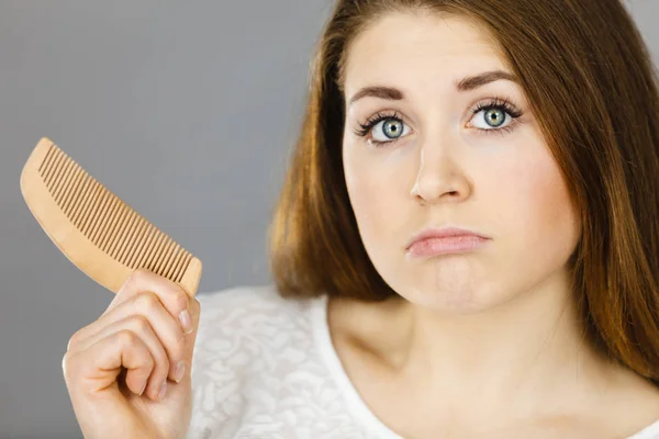 Aantrekkelijke jonge vrouw wordt verward met kam — Stockfoto