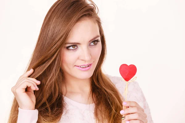 Flirty woman holding red wooden heart on stick — Stock Photo, Image