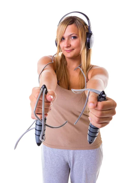 Blonde woman holding skipping rope wearing headphones — Stock Photo, Image