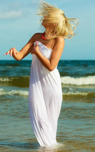 Blondynka w sukience chodząca w wodzie — Zdjęcie stockowe