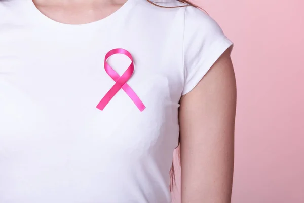 Roze lint op vrouw borst ter ondersteuning van de borst kanker veroorzaken — Stockfoto