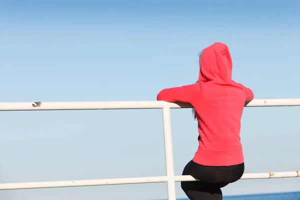 桟橋が屋外で地平線を見て座っている女性 — ストック写真