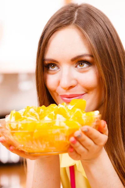 Mujer sostiene cuenco lleno de frutas de naranja en rodajas —  Fotos de Stock