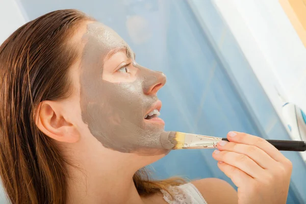 Mulher aplicando máscara facial de lama — Fotografia de Stock