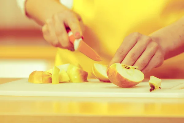 Donna casalinga in cucina taglio mela frutta — Foto Stock