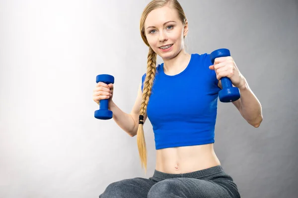 Teenage woman working out at home with dumbbell — Stock Photo, Image