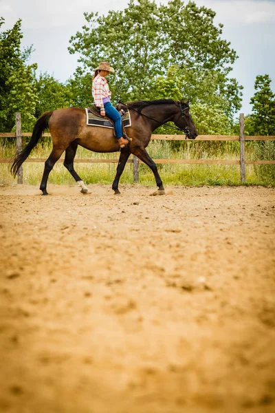 Cowgirl doen paard rijden op platteland weide — Stockfoto