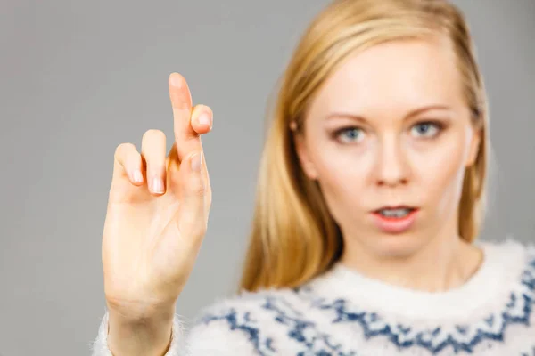 Teenage blonde woman making promise gesture — Stock Photo, Image