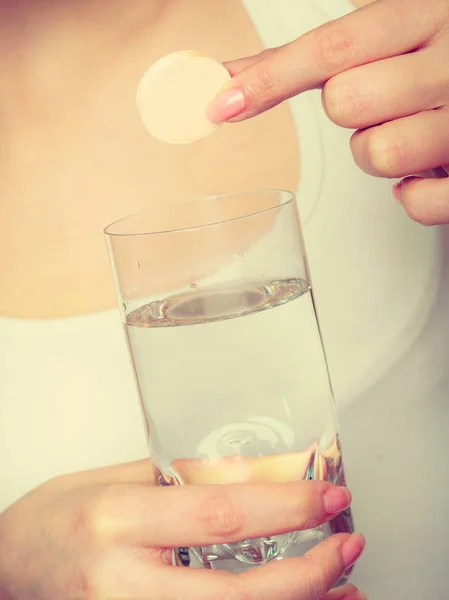 Donna che tiene il bicchiere con acqua e compressa effervescente — Foto Stock