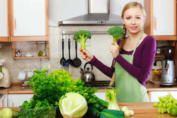Žena v kuchyni s zelená zelenina brokolice v ruce — Stock fotografie
