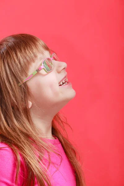Jovem menina feliz em óculos olhando para algo — Fotografia de Stock