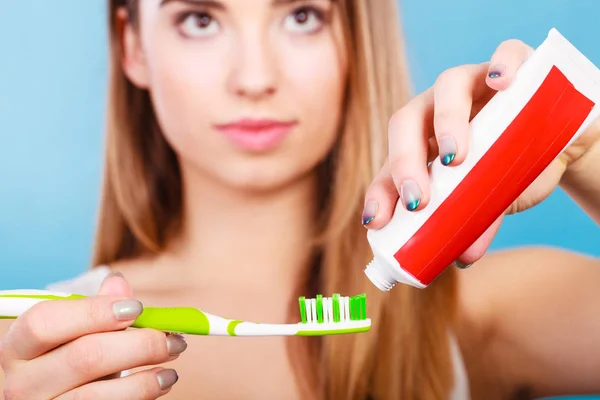 Mujer aplicando pasta de dientes en su cepillo de dientes —  Fotos de Stock