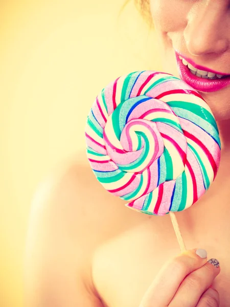 Mujer sostiene colorido caramelo piruleta en la mano — Foto de Stock