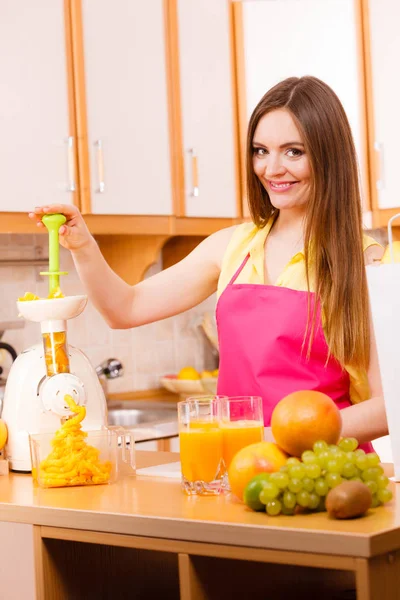 ジューサー機でオレンジ ジュースを作って女性 — ストック写真