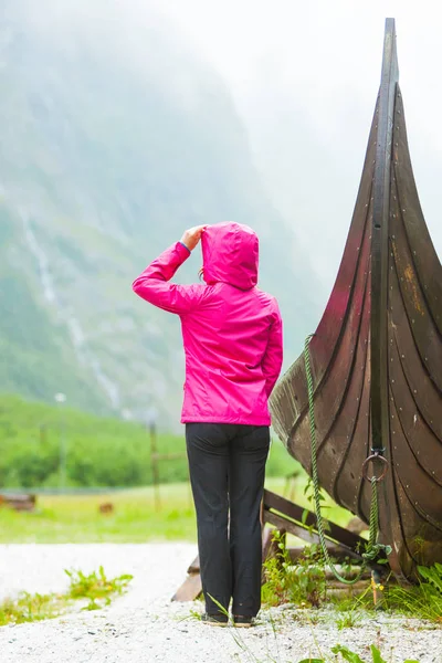 Turista de pie cerca de viejo barco vikingo de madera en la naturaleza noruega —  Fotos de Stock