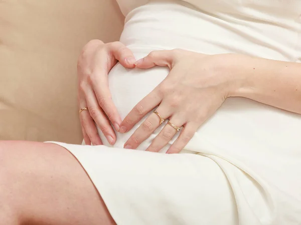 Mulher grávida em roupas brancas mostrando barriga — Fotografia de Stock