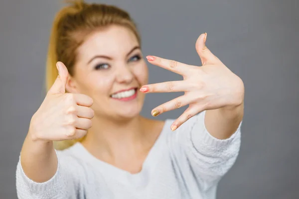Šťastná žena ukazuje její ruka a palec — Stock fotografie