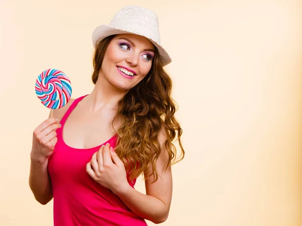 Mujer sostiene colorido caramelo piruleta en la mano —  Fotos de Stock