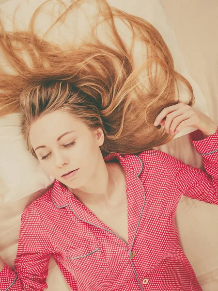 Genç kadın pijama giymiş yatakta yatarken — Stok fotoğraf
