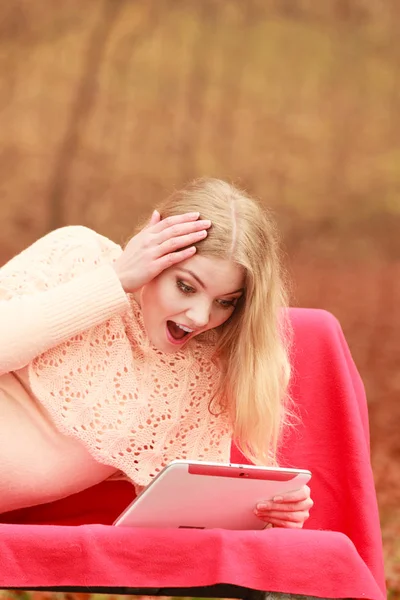 Vrouw in vallen park met surfen op internet tablet. — Stockfoto