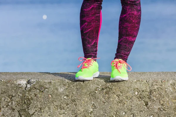 Weibliche Beine Füße in leuchtender Farbe gelbe Schuhe am Meer. — Stockfoto