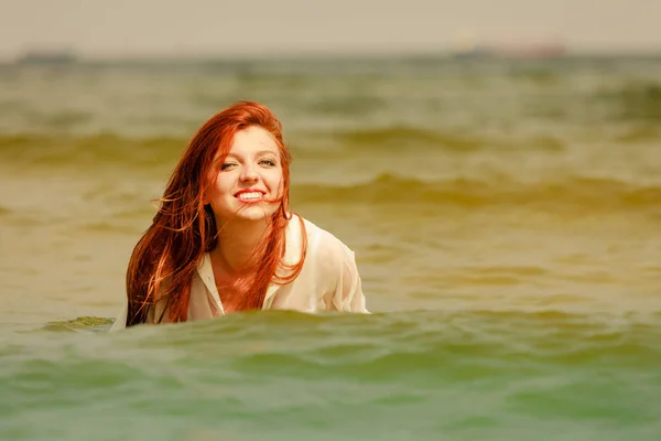 Roodharige vrouw spelen in water gedurende de zomermaanden — Stockfoto