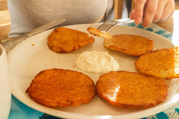 Leckere Kartoffelpuffer auf Teller mit saurer Sahne — Stockfoto