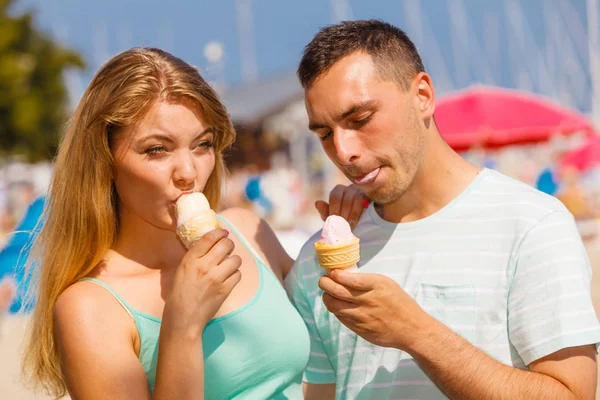 Mężczyzna i kobieta jedzący lody na plaży — Zdjęcie stockowe